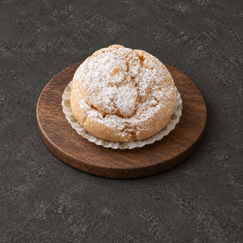 Round golden Cream Puff with a lightly dusted top